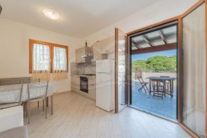 une cuisine et une salle à manger avec vue sur un patio dans l'établissement La Perla della Biodola - Goelba, à Portoferraio