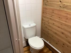 a bathroom with a white toilet and a wooden wall at Cabin 4 in Kent