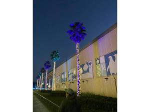 藤沢市にあるEnoshima Beach - Vacation STAY 07420vの椰子の木の灯る建物を通り過ぎる男