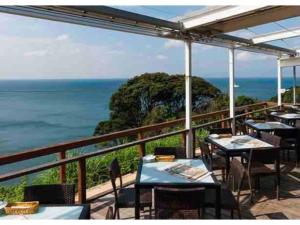 een balkon met tafels en stoelen en de oceaan bij Enoshima Beach - Vacation STAY 07420v in Fujisawa