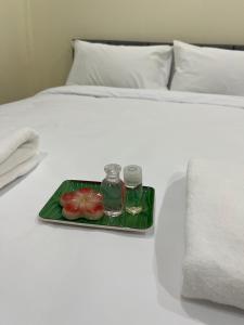 un vassoio con pomodori e due bevande su un letto di KP House Bueng Kan a Seka