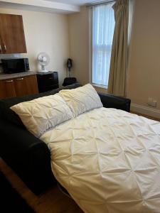 a bedroom with a bed with a white comforter at Entire Apartment boutique king size bed near Town Centre in Colchester
