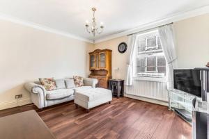a living room with a couch and a tv at 2 Bedroom Duplex Apartment in Leicester