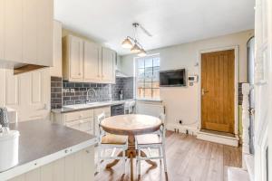 a kitchen with white cabinets and a table and a stool at 2 Bedroom Duplex Apartment in Leicester