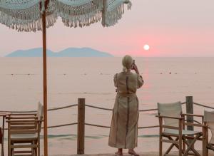 a woman taking a picture of the ocean at Yacht Hotel in Vlorë