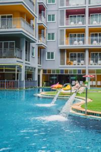 a pool with a water slide in front of a building at Bauman Residence in Patong Beach
