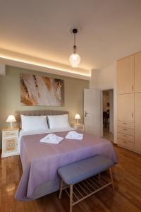 a bedroom with a large bed with a purple blanket at Blue Ark Acropolis Compass in Athens