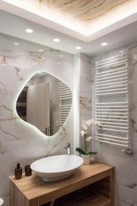 y baño con lavabo blanco y espejo. en Blue Ark Acropolis Compass, en Atenas