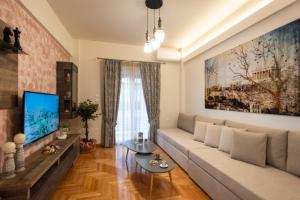 a living room with a couch and a tv at Blue Ark Acropolis Compass in Athens