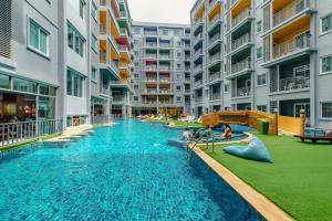 a large swimming pool with a slide in a building at Bauman Residence in Patong Beach