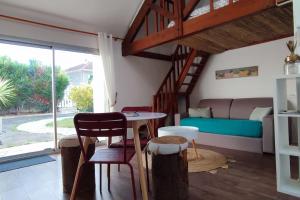een woonkamer met een tafel en een bank bij Maisonnette 2/4 Pers-Jardin-Calme-Parking gratuit in Billère