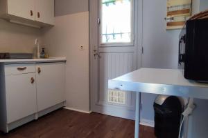 a kitchen with a white counter and a window at Maisonnette 2/4 Pers-Jardin-Calme-Parking gratuit in Billère