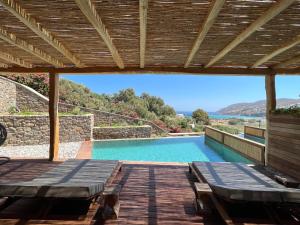 una piscina con sillas y una terraza de madera en Mileo en Kalo Livadi