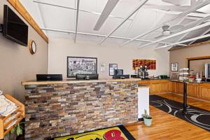 a lobby with a brick wall and a counter at Super 8 by Wyndham Branson - Shepherd of the Hills Exwy in Branson
