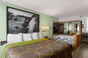 ein Hotelzimmer mit einem großen Bett und einem Bad in der Unterkunft Super 8 by Wyndham Branson - Shepherd of the Hills Exwy in Branson