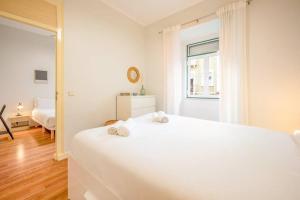ein weißes Schlafzimmer mit einem weißen Bett und einem Fenster in der Unterkunft GuestReady - Spring break in Lisbon in Lissabon