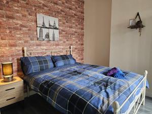 a bedroom with a bed and a brick wall at Fife House - Welcome Short Stays in Derby