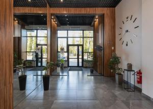 a lobby with a clock on the wall and plants at Nyvky Residence in Kyiv