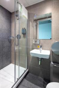 La salle de bains est pourvue d'un lavabo et d'une douche. dans l'établissement Clink i Lár, à Dublin