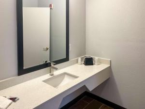 W łazience znajduje się umywalka i lustro. w obiekcie Motel 6 Hurricane, WV w mieście Hurricane