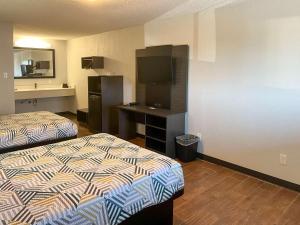 Habitación de hotel con 2 camas y TV en Motel 6 Hurricane, WV, en Hurricane