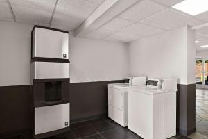 Habitación con armarios blancos, lavadora y secadora. en Rodeway Inn, en Commerce
