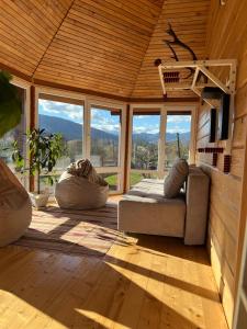 a living room with a couch and some windows at Domashnya Oselya in Verkhovyna