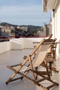 a wooden lounge chair sitting on top of a balcony at Nostos - Luxury Apartment in Agrinio in Agrinio