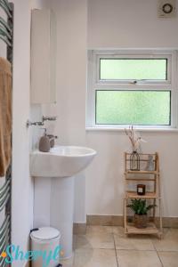 a bathroom with a sink and a window at Scenery Senary by Sheryl - Large house, Right in Town Centre, Near Northampton Gen Hospital in Northampton