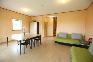 KoplyčninkaiにあるAurora housesのリビングルーム(テーブル、緑のソファ付)
