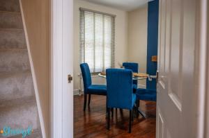 a dining room with blue chairs and a table at Scenery Senary by Sheryl - Large house, Right in Town Centre, Near Northampton Gen Hospital in Northampton
