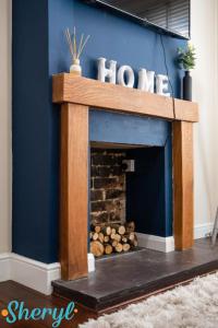 a fireplace in a living room with a blue wall at Scenery Senary by Sheryl - Large house, Right in Town Centre, Near Northampton Gen Hospital in Northampton