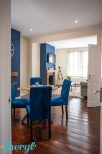a living room with a table and blue chairs at Scenery Senary by Sheryl - Large house, Right in Town Centre, Near Northampton Gen Hospital in Northampton