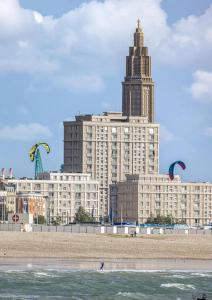 a large building with kites flying over the beach at Appartement Louise in Le Havre