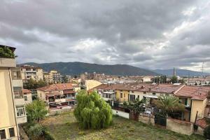 Piccolo appartamento a Prato في براتو: اطلاله على مدينه بها مباني وجبال