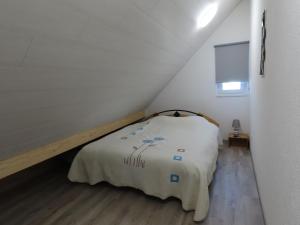 Dormitorio pequeño con cama en el ático en Les P'tits Loups, en Courtedoux