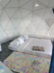 un letto bianco in una stanza con parete di อาฉ่างแคมป์ Achang Camp a Mon Jam