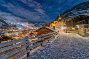 een dorp in de sneeuw 's nachts met een hek bij Casa Cara: Retreat Apartment Sauna in Tacherting