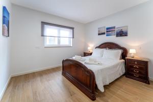 a bedroom with a large bed and a window at T2 Paulo's Apartment in Nazaré