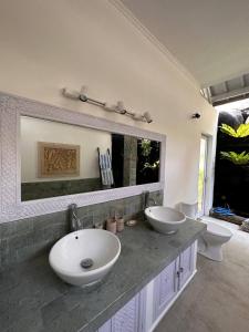 ein Badezimmer mit zwei Waschbecken und einem großen Spiegel in der Unterkunft Báraka Villa in Denpasar