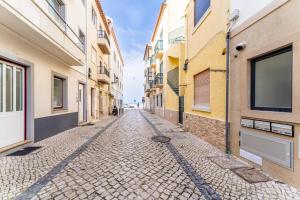 an empty street in an alley between buildings at T2 Paulo's Apartment in Nazaré