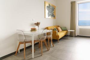 a living room with a table and chairs and a couch at Cà de Mâ - Sea Front Suite in Genoa