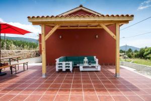 a pavilion with a table and a bench on a patio at Casa Menora Playa de Carnota in Carnota
