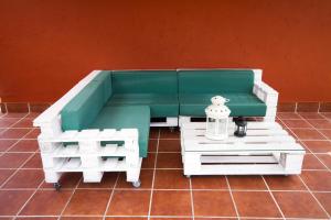 a green and white couch and tables on a tile floor at Casa Menora Playa de Carnota in Carnota