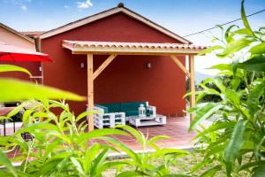 a red house with a gazebo on a patio at Casa Menora Playa de Carnota in Carnota