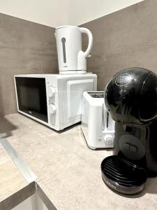 a coffee maker sitting on a counter next to a microwave at Stade de France 8min - Idéal JO 2024 in Saint-Denis