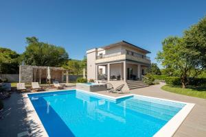 a swimming pool in front of a house at Villa Dali - luxury holiday house in relaxing area in Sičane