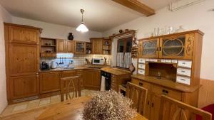 a large kitchen with wooden cabinets and a table at Chalupa Lučany in Lučany nad Nisou