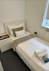 a bedroom with a bed with two towels on it at The Maison- Cozy home stay in Nottingham