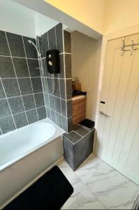 a bathroom with a bath tub and a shower stall at The Maison- Cozy home stay in Nottingham